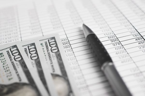 Money, accounting documents invoices and a pen. Close-up, low angle view, selective focus.